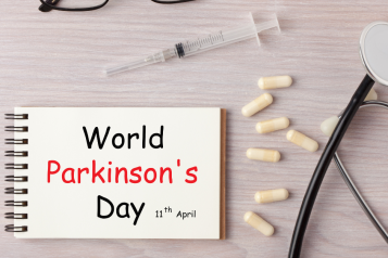 glasses, syringe, medication and stethoscope and the words World Parkinson's Day written on a pad